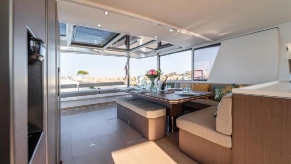 The stylish dining area of the Bali 5.4 catamaran offers a luxurious setting with views of the Italian coast.