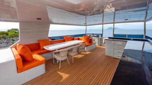 Das moderne und komfortable Außendeck der Yacht Simay M zeichnet sich durch einen Sitzbereich mit orangefarbenen Kissen