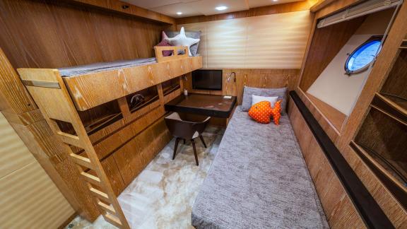 This cozy kid-friendly cabin on Monte Carlo 86 Giorgio includes a bunk, desk, and sea view porthole.