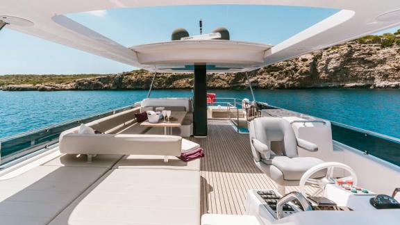 Comfortable white cushions and seating area on the upper deck of Sirena 64.