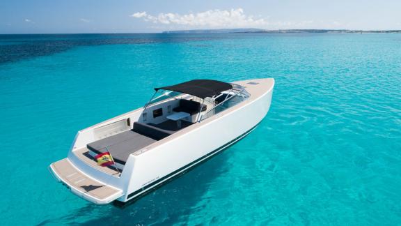 The Smart Ass motor yacht is seen from the rear, floating in clear waters.