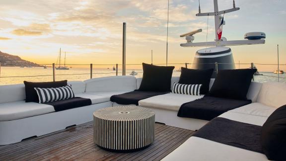 Among motor yacht rental options in Athens Sounion II upper deck seating area is seen with sunset view.
