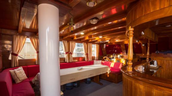 Warmer und einladender Salon mit bequemen Sitzgelegenheiten und Holzausstattung auf der Gulet Erşen 1 im Hafen von Bodru