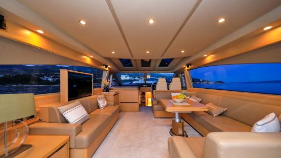 Style and comfort in the spacious salon of the motor yacht Spice of Life II, with an evening view.