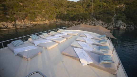 The spacious sun deck of the gulet Queen of RTT in Fethiye is equipped with numerous sun loungers and cushions, ideal fo