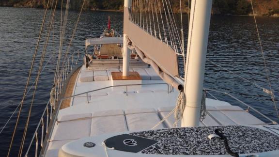 Foredeck of Gulet Simi with comfortable sun loungers and a paddleboard, perfect for watersports and relaxation.