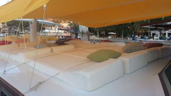 Relaxation area on Gulet Cheers with comfortable cushions and pillows, perfect for sunbathing.