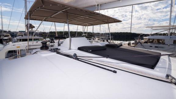 The spacious sun deck of the Saelma Lagoon 450 with cushioned lounge areas under a canopy.