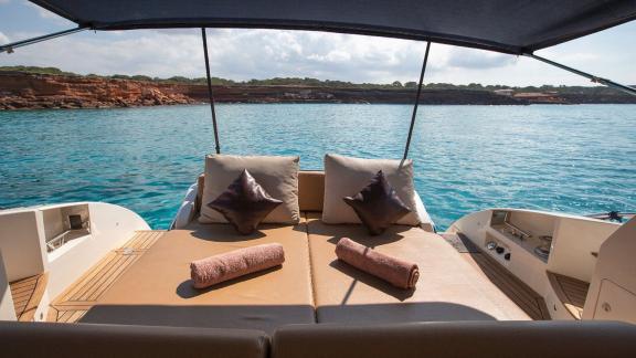 The aft deck of motor yacht Vida Boa, with comfortable cushions and sun loungers, is perfect for relaxing with a sea vie