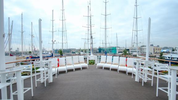 The outdoor terrace on Harmony II motor yacht offers comfortable seating and a view of the sea.