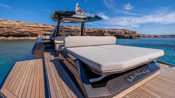 The aft deck of Jemima motor yacht offers a comfortable sunbathing area against the turquoise waters.