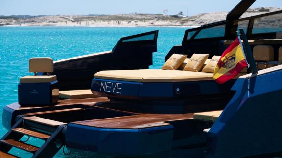 The aft deck of the Neve motor yacht offers a sea view and a comfortable seating area.