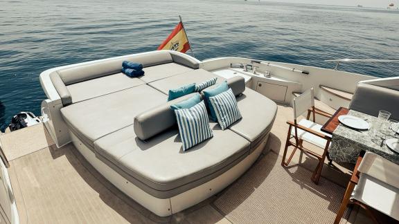 Spacious seating area on the aft deck of motor yacht Esperanza, equipped with comfortable cushions and offering a sea vi