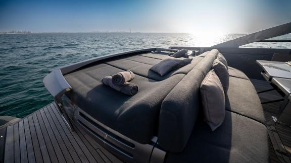 The comfortable sunbathing area on the aft deck of the Pershing 70 is perfect for luxury yacht rental in Dubai.