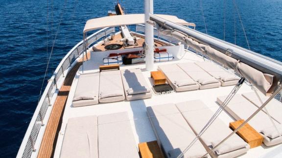 Sun loungers on the deck of a gulet with a view of the open sea.