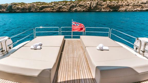 Two large beige sunbeds with sea view on upper deck of Sirena 64 yacht.