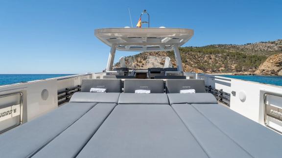 Breite graue Liegefläche der Motoryacht Fjord V mit Meerblick.