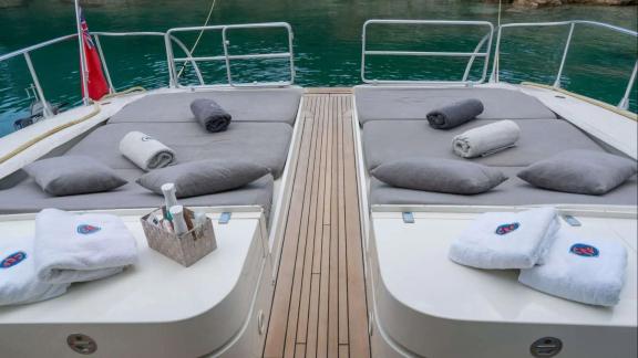 Zu sehen ist der Sonnenbereich am Heck der Atrato in Athen mit zwei Liegeflächen und Handtüchern.