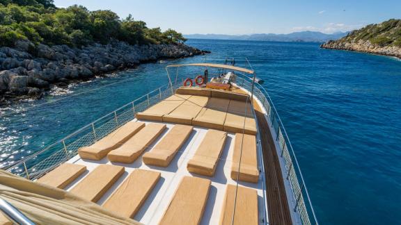 Das großzügige Sonnendeck der Gulet ÇağAy bietet bequeme Liegen in einer ruhigen Bucht bei Fethiye.