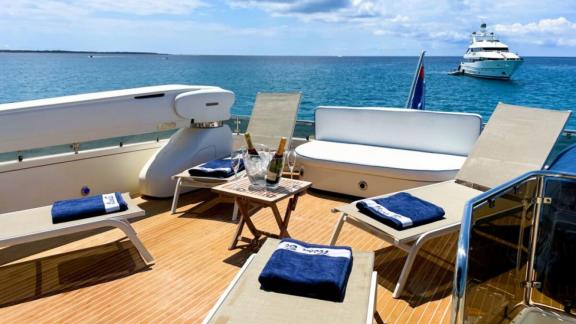 The sunbathing area of motor yacht Riva 21 offers loungers, towels, and drinks in a comfortable setting.