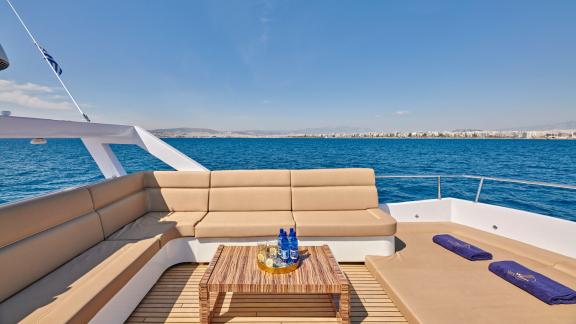 Comfortable seating area on the motor yacht Wide Liberty with a view of the Greek coast.