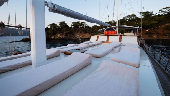 Geräumiges Sonnendeck der Gulet Pronto White mit bequemen Liegen, perfekt für Entspannung in der Abenddämmerung.