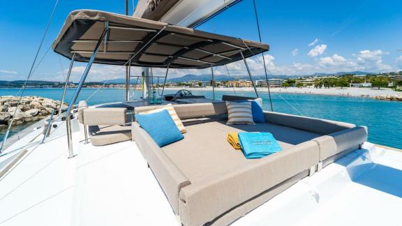 Comfortable sunbathing area on the deck of a Bali catamaran, overlooking the coast and sea.