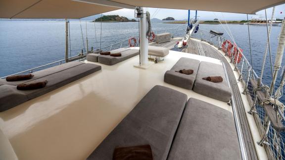 Comfortable lounging areas on the sun deck of a gulet with views of the sea and islands.