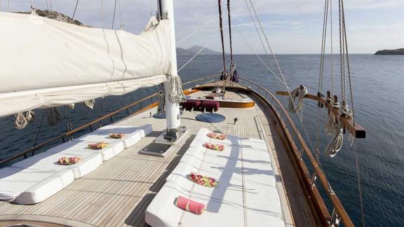 Sun loungers and cushions on the bow of a traditional gulet.