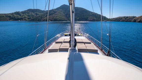 View of the front deck of the gulet with sun loungers and sea horizon.