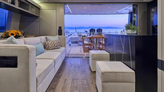 The modern salon of Adara yacht opens to the aft deck with a scenic dining area.