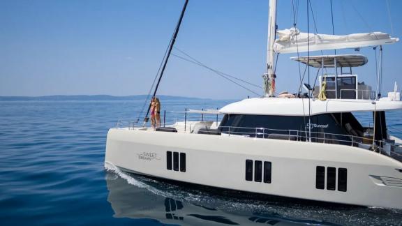 Катамаран Sweet Dreams модели Sunreef 50 элегантно скользит по воде, предлагая комфортное морское путешествие.