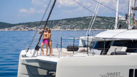На носовой палубе катамарана Sweet Dreams Sunreef 50 пары наслаждаются морскими видами и атмосферой у Кастелы.