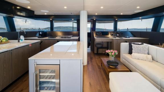 В салоне катамарана кухня, мягкая мебель и большие окна с панорамным видом.