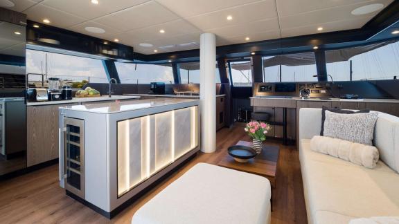 В салоне катамарана Sunreef 50 стильная кухня с подсветкой и уютная зона отдыха.