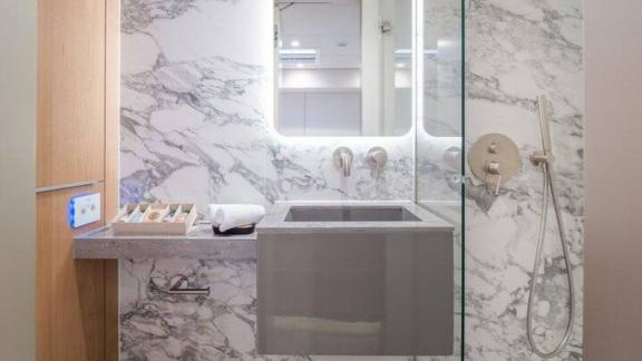 In Kastela Zara’s bathroom features marble wall modern sink and glass enclosed shower.