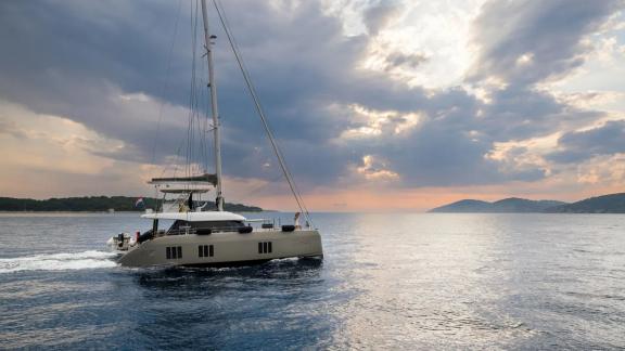 Near Kastela Zara cruises gently at sunset with soft light and calm waves all around.