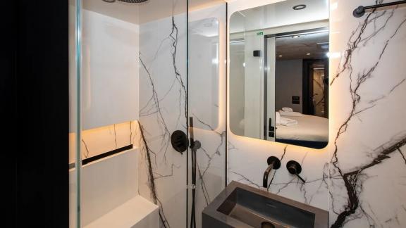 The Sunreef 60 Mr. Si bathroom combines sleek black fixtures with marble-patterned walls for a modern elegant look.