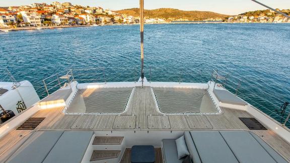 The spacious foredeck of Sunreef 60 Mr. Si offers an unmatched view of the scenic coast of Rogoznica at sunset.