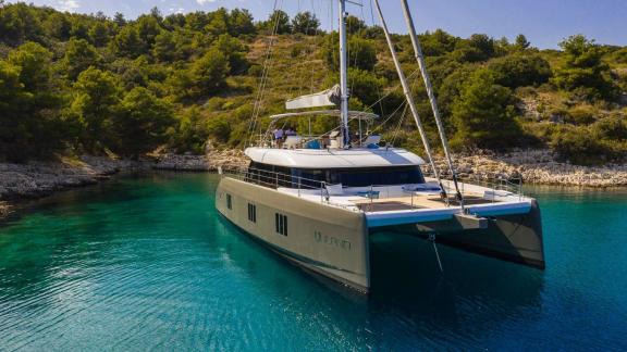 Vulpino, a modern Sunreef 60 catamaran, anchored in a calm bay near Kastela.