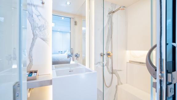 In Kastela Vulpino’s bathroom has a marble style shower modern sink and full wall mirror.