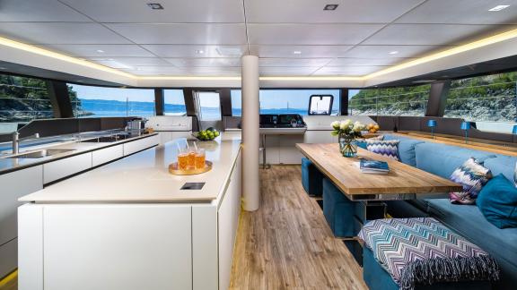 Inside Vulpino in Kastela is a bright saloon with sofas, dining table and large windows.