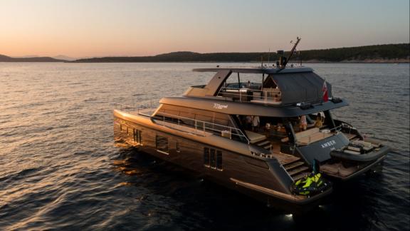 Elegant Sunreef 70 catamaran Amber One anchored off Kastela during golden hour.