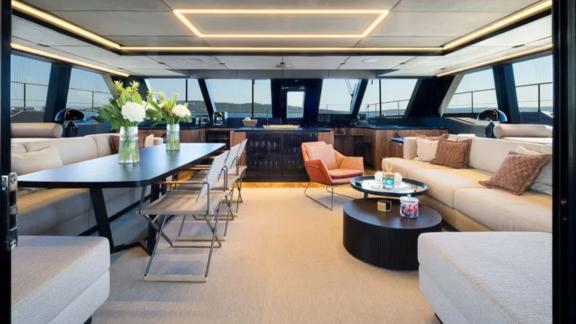 Spacious salon on Amber One with dining area and sofas cruising near Kastela.