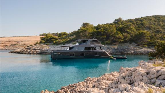 Amber One Sunreef 70 catamaran anchored in a turquoise bay near Kastela cliffs.