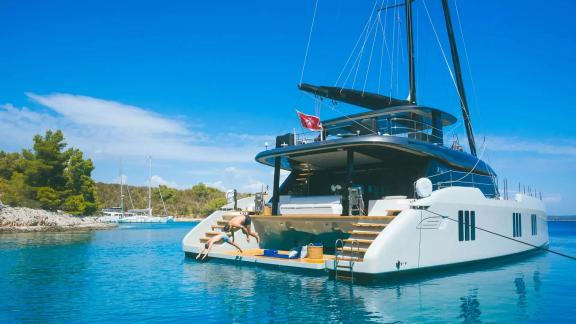 Vom Heck der N1 Sunreef 70 springen Gäste ins klare Wasser vor Kastela.