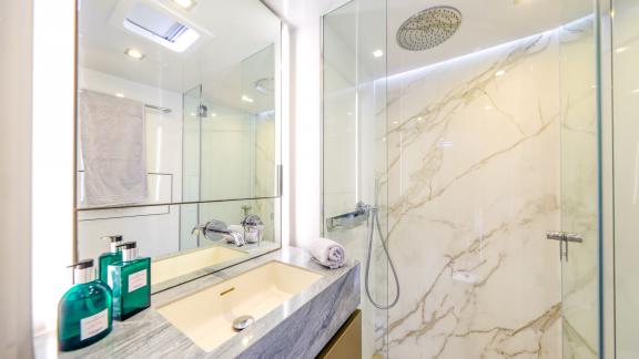 Featuring a marble shower and sleek vanity, Honeybird’s bathroom offers high-end comfort for charter in Šibenik.