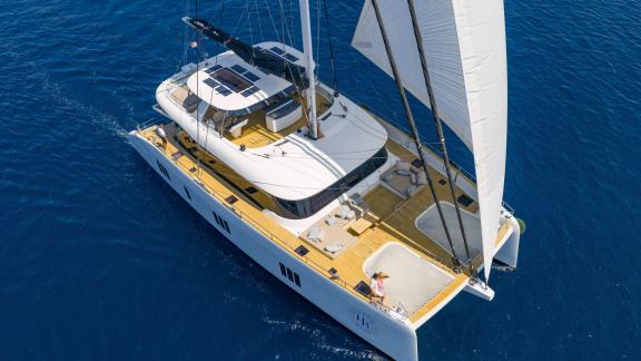 The luxurious Honeybird catamaran is under sail for charter near the scenic shores of Šibenik.