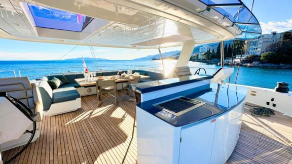 The spacious seating and dining area on Honeybird’s flybridge offers a peaceful charter setting in Šibenik.