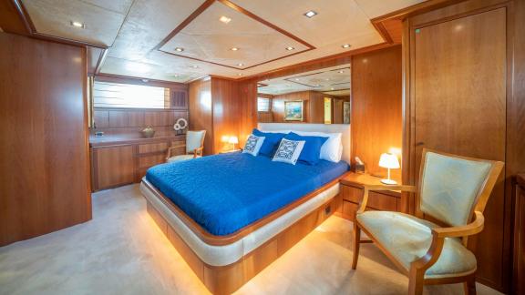 Die Masterkabine der Yacht Sanref bietet ein großes Bett, Holzeinrichtung und eine elegante Atmosphäre.